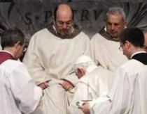 El Papa lava los pies de un sacerdote durante la Misa de Jueves Santo