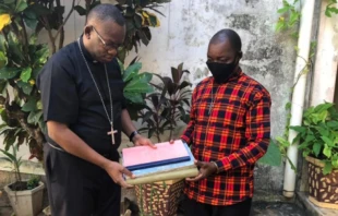 Paulo Matica entregando los documentos de la Iglesia en Palma al Obispo de Pemba, tras ataque de ISIS. Cru00e9dito: ACN. 