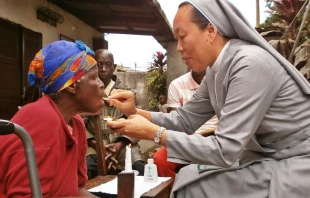 Religiosa da la Comuniu00f3n a una mujer en silla de ruedas. Cru00e9dito: Ayuda a la Iglesia Necesitada. 