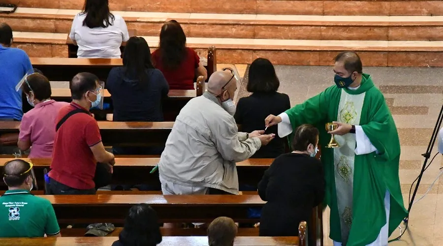 Sacerdote da la Comunión durante una Misa en la Parroquia de San Fernando de Dilao en Paco, Manila, 25 de julio de 2021. Crédito: Cortesía de Paco Church a CBCP.