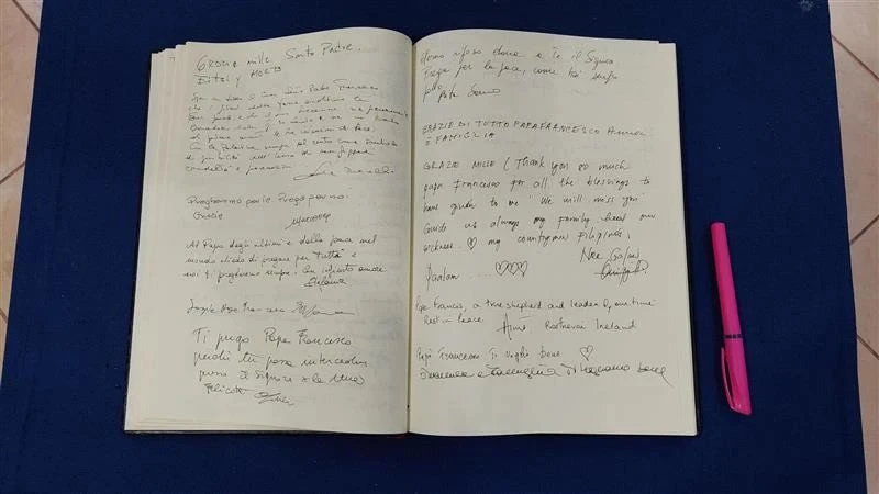 Las páginas del libro conmemorativo muestran mensajes manuscritos de los fieles expresando su gratitud y despedida al Papa Francisco. Hay bolígrafos listos para que más visitantes añadan sus homenajes. Crédito: Elias Turk / ACI MENA.