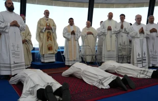 Los 3 nuevos sacerdotes del Camino Neocatecumenal postrados en la Domus Galilaeae en Galilea, Tierra Santa. Crédito: Latin Patriarchate of Jerusalem.