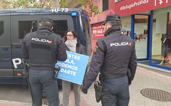 Voluntaria de 40 Días por la Vida intenta rezar por el fin del aborto en Madrid, ante la presencia policial. Crédito: Nicolás de Cárdenas / ACI Prensa.