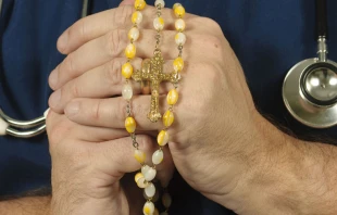 Un mu00e9dico sostiene su Rosario. Cru00e9dito: Shutterstock 