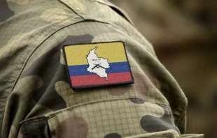 Bandera de las Fuerzas Armadas Revolucionarias de Colombia (FARC) con uniforme militar. Cru00e9dito: Shutterstock. 