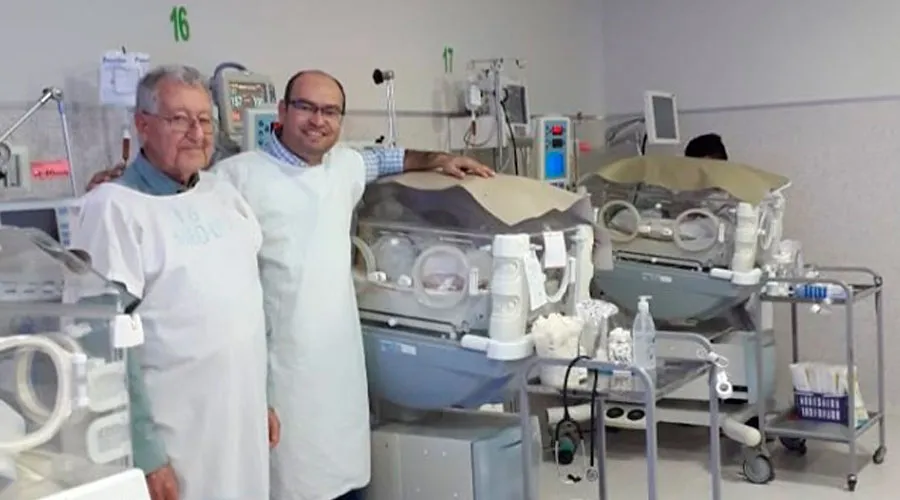 Erwin Bazan y el Padre Jordá junto a la incubadora de Victoria en el Hospital de la Mujer en Santa Cruz. Crédito: Facebook Erwin Bazán