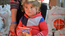 Una niña siria sostiene un ejemplar de la Biblia. Foto: Ayuda a la Iglesia Necesitada