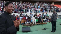 El P. Simbini junto al coro en el estadio Zimpeto en Maputo, Mozambique. Crédito: ACI África