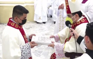 Rau00fal Antonio Vega Gonzu00e1lez el du00eda de su ordenaciu00f3n diaconal recibiendo el Evangeliario de manos de Mons. Rolando u00c1lvarez. Cru00e9dito: Diu00f3cesis de Matagalpa 