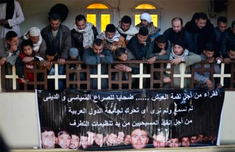 Egipcios con pancarta que muestra a los 21 cristianos coptos decapitados por el Estado Islámico en Libia / Foto: Twitter?w=200&h=150