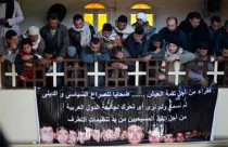 Egipcios con pancarta que muestra a los 21 cristianos coptos decapitados por el Estado Islámico en Libia / Foto: Twitter