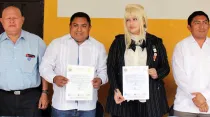 El alcalde de Oxkutzcab, Raúl Romero Chel, sostiene una copia del supuesto convenio junto a Harriet Turner. Foto: Facebook / Ayuntamiento de Oxkutzcab.