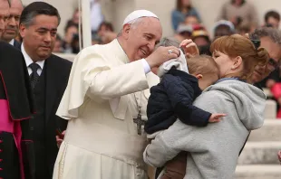 Papa Francisco junto a una madre y su hijo en brazos. Foto: Daniel Ibáñez / ACI Prensa. 