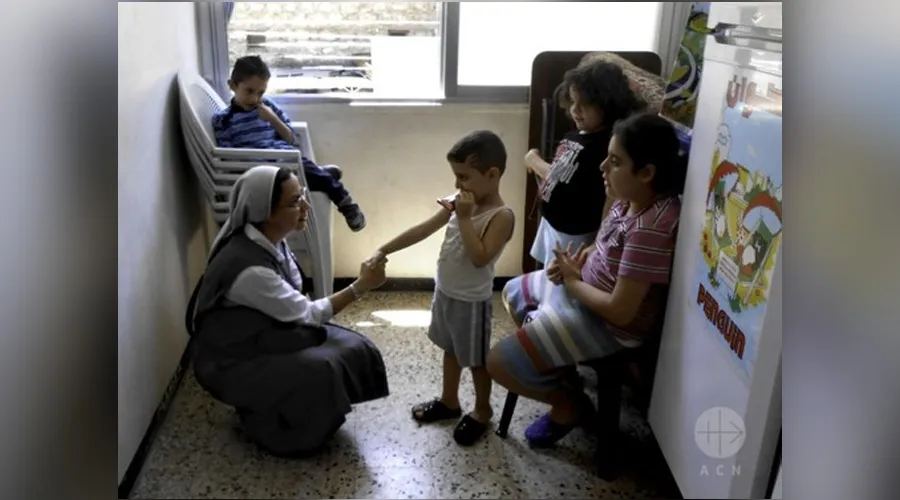 Hermana Annie Demerijan, colaboradora de Ayuda a la Iglesia Necesitada en Siria, junto a niños cristianos en Alepo. Foto: AIN.