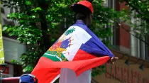 Imagen referencial / Hombre lleva la bandera de Haití sobre su espalda. Foto: Flickr de abdallahh (CC BY 2.0).