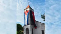 La bandera de Cuba y la del movimiento 26 de julio en una iglesia en Cuba. Crédito: Diócesis de Santa Clara