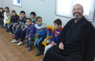 P. Luis Montes y niu00f1os de un jardu00edn de infantes en un campamento de refugiados en Irak. Foto: Instituto del Verbo Encarnado. 