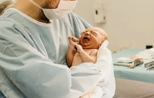 Un mu00e9dico sostiene un bebu00e9 reciu00e9n nacido. Cru00e9dito: Jonathan Borba / Unsplash 