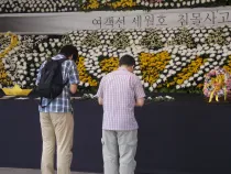 En Seúl dos personas dejan flores ante el memorial del ferry de Sewol (foto Walter Sánchez Silva / ACI Prensa)