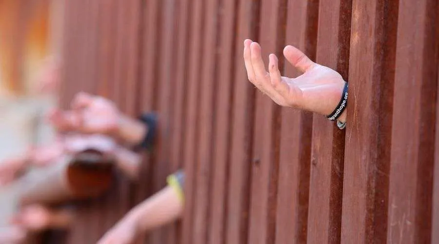 Manos a través del muro fronterizo de Estados Unidos y México. Foto: Flickr Boston Catholic (CC-BY-ND-2.0).?w=200&h=150