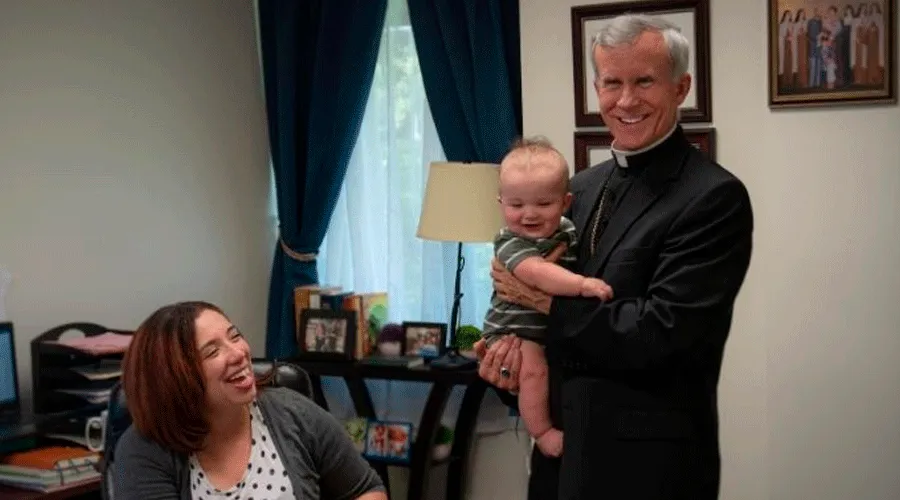 Deanna Johnston, directora de vida familiar del Instituto San Felipe, observa cómo Mons. Joseph Strickland sostiene a su bebé / Crédito: Cortesía del Instituto San Felipe?w=200&h=150