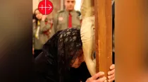 Una cristiana reza ante un crucifijo en Irak (Foto Ayuda a la Iglesia Nececesitada / AIN)