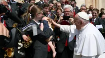 El Papa saluda a la hija de un miembro de la orquesta tras la Audiencia General. Crédito: Vatican Media.