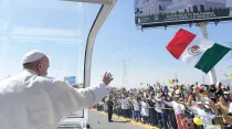 Papa Francisco saluda y una bandera mexicana ondea en su camino. Crédito: Vatican Media.