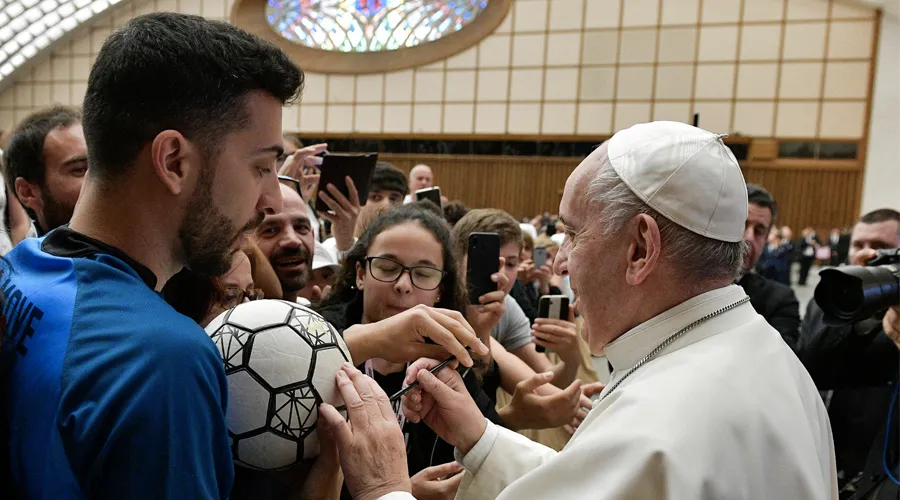 El Papa Francisco firma balón de fútbol en el Aula Pablo VI. Foto: Vatican Media / ACI