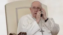El Papa Francisco atiende una llamada telefónica durante la Audiencia General. Crédito: Daniel Ibáñez/ACI Prensa