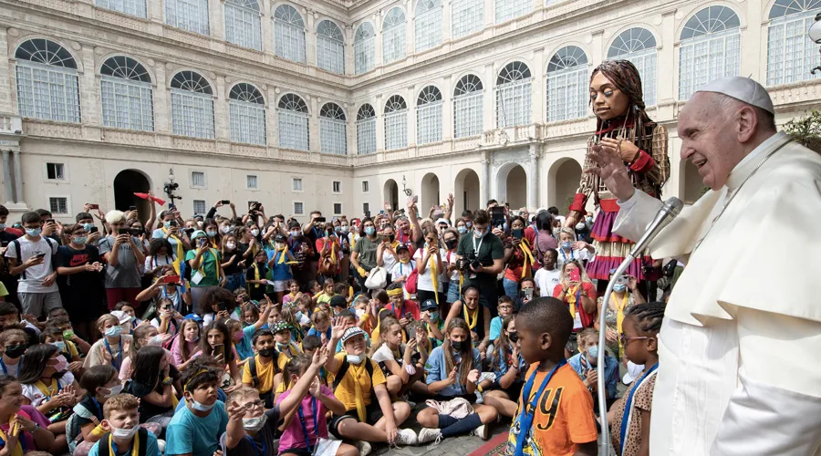 El Papa bendice a niños junto a marioneta gigante que representa a una niña refugiada