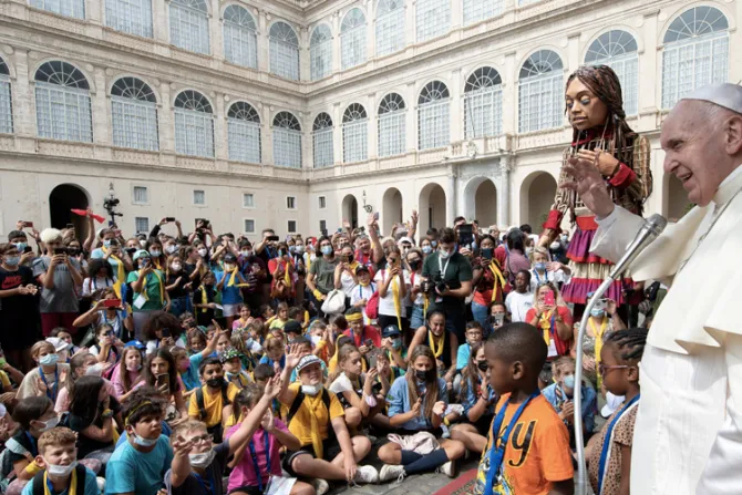 El Papa bendice a niños junto a marioneta gigante que representa a una niña refugiada