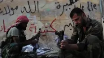Rebeldes sirios limpian sus armas. Foto: VOA / Wikipedia / Dominio Público.