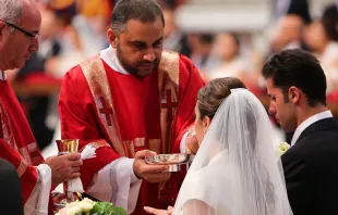 Pareja de recién casados por el Papa Francisco recibe la Comunión. Foto: Lauren Cater / ACI Prensa 