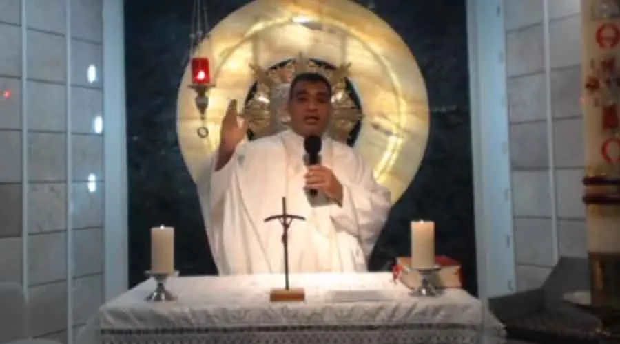 P. Ricardo López celebra la Misa el 22 de abril, mientras era amenazado por un desconocido. Crédito: Facebook de Parroquia San Juan Bautista.