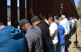 Sacerdotes scalabrinianos rezan ante muro que separa Mu00e9xico y Estados Unidos. Cru00e9dito: Cortesu00eda Casa del Migrante en Tijuana. 