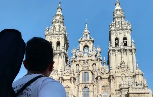 Un peregrino llega a las puertas de la Catedral de Santiago de Compostela. Cru00e9dito: Cathopic 