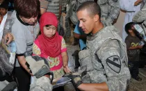 Soldado estadounidense entrega útiles educativos a niño en Irak. Foto: United States Forces Iraq (CC BY-NC-ND 2.0)