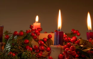 Corona de Adviento con tres velas encendidas, incluyendo la rosada del tercer domingo. Cru00e9dito: Shutterstock 