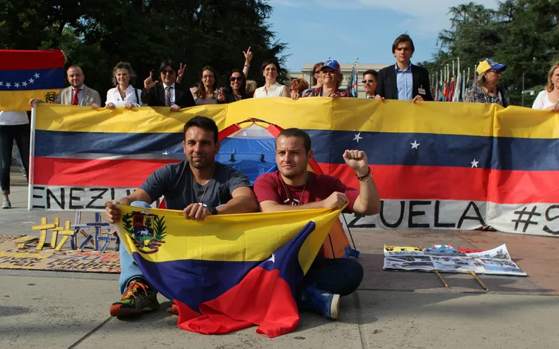 Alejandro Suarez y Eusebio Costa sostienen una bandera de Venezuela. Atrás Ángel Carromero y Regis Iglesias, entre otros. Foto: Facebook de UN Watch?w=200&h=150