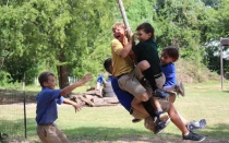 Niños juegan con un columpio durante el recreo.