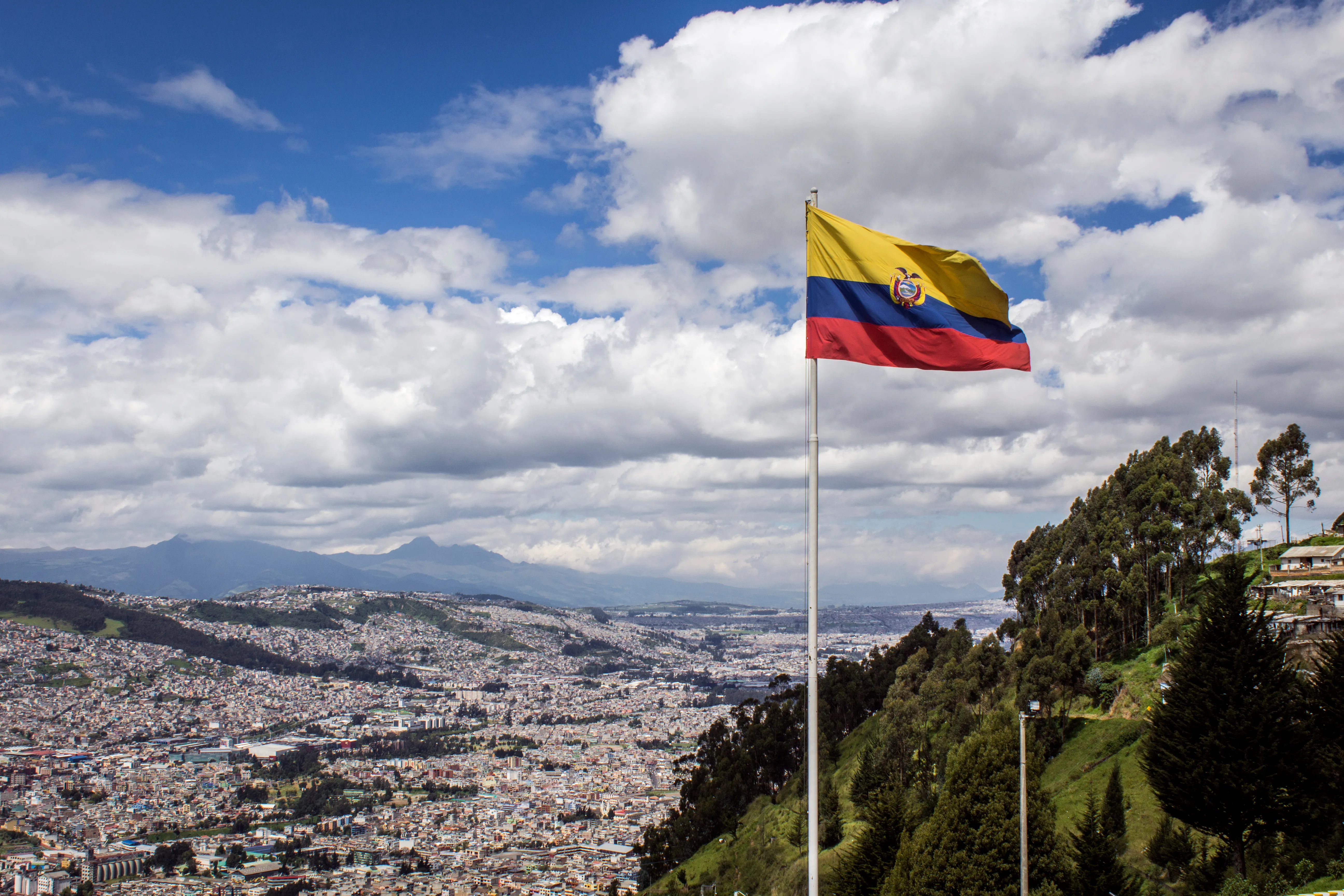 Bandera de la República del Ecuador, en un día soleado con la ciudad de Quito al fondo.?w=200&h=150