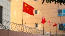 Banderas chinas en un muro de alambre en Kashgar (Kashi), Xinjiang, China