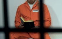 Imagen referencial de una persona en la cárcel leyendo la Biblia.