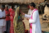 Fieles católicos indios reciben la Comunión durante una Misa al aire libre en la aldea de Mitrapur, Bengala Occidental, India.