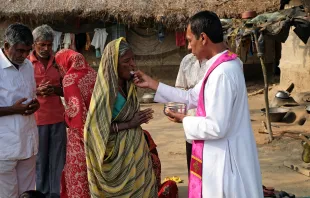 Fieles católicos indios reciben la Comunión durante una Misa al aire libre en la aldea de Mitrapur, Bengala Occidental, India. Crédito: Zvonimir Atletic - Shutterstock