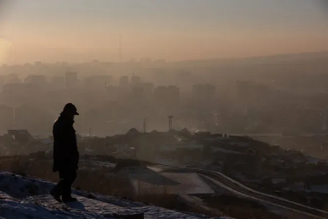 Fotografía tomada el 16 de enero de 2022 muestra a un hombre observando el humo que se cierne sobre las casas en Ulán Bator, la capital de Mongolia.?w=200&h=150