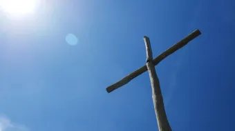 Una cruz se eleva hacia el cielo azul. Imagen referencial.