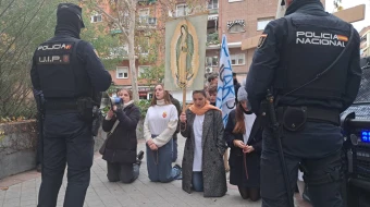 Jóvenes rezan por el fin del aborto el día de los Santos Inocentes de 2022 en Madrid, vigilados por la Policía.