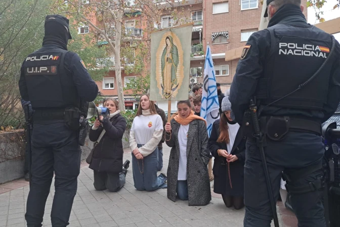 Jóvenes rezan por el fin del aborto el día de los santos inocentes en Madrid, vigilados por la Policía.
